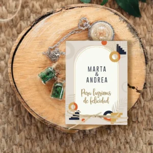 Estuche de pañuelos personalizado para bodas con los nombres 'Marta & Andrea'. Diseño moderno con elementos geométricos en tonos beige, dorado y negro, acompañado de la frase 'Para lágrimas de felicidad' y un lazo rústico decorativo.