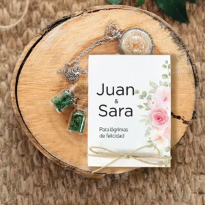 Detalle de boda con diseño floral y personalizado con los nombres 'Juan & Sara'. Estuche para pañuelos con la frase 'Para lágrimas de felicidad', decorado con rosas y un lazo rústico.