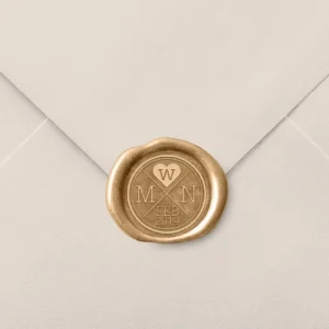 Sello de lacre dorado con diseño personalizado de iniciales 'M & N', un corazón con la letra 'W' y la fecha 'Feb 2019', decorando el cierre de un sobre de invitación de boda en color beige.