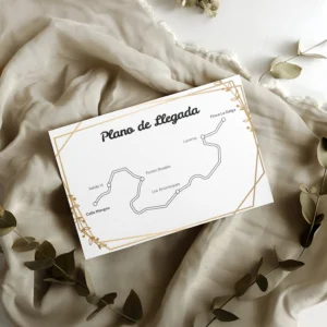 Plano de llegada para boda con diseño floral clásico, líneas negras sobre fondo blanco, enmarcado con detalles dorados, sobre tela beige y decorado con ramas secas